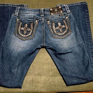 Miss me Jeans 27x34 signature boot with a cross/horseshoe design on pocket